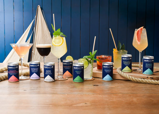 Bar Buoy cocktails served in their glasses beside the cans