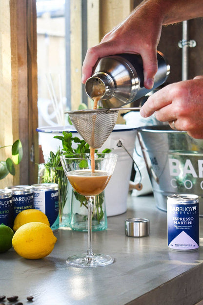 how to serve - Bar Buoy Espresso Martini cocktail being poured from a shaker into a coupe glass, with the can alongside